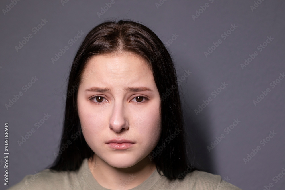 portrait of charming sad brunette woman in marsh color t-shirt on grey wall background. actress acting, emotion portrait of charming sad brunette woman in marsh color t-shirt on grey wall background. actress acting, emotion
