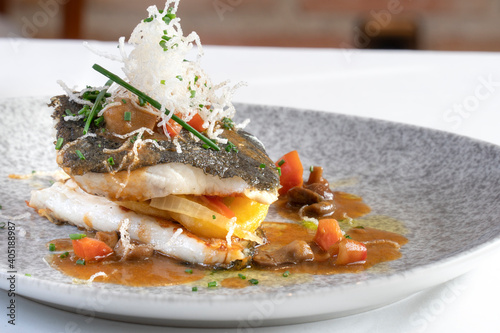 Grilled turbot with vegetables and beef juice, decorated with seafood noodles
