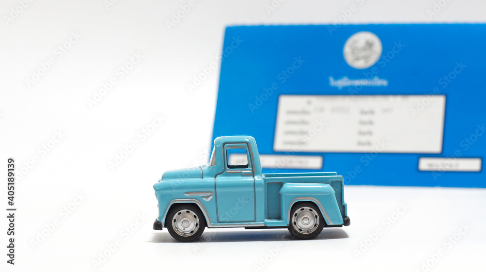 Focus on the car toy, and blur a vehicle registration certificate.Annual car registration concept.