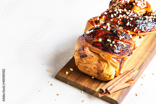 Babka or brioche bread with apricot jam and nuts. Homemade pastry for breakfast. Concrete background.