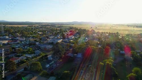 Aerial descend over rural town facing the sun at sunset in Australia photo