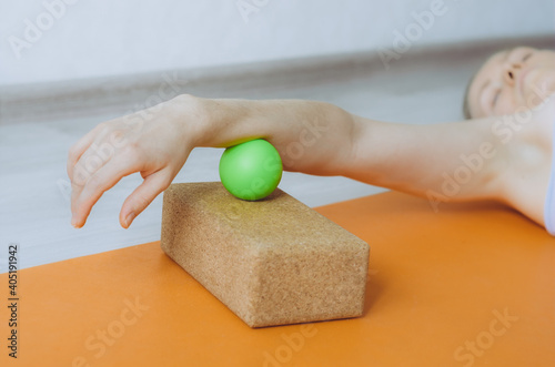 Hypermobile forearm myofascial release with massage ball on cork block photo