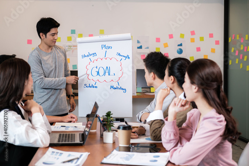 Portrait businesspeople standing by white board and giving presentation to colleagues during meeting in conference room. explaining something meeting to colleagues. Project results.