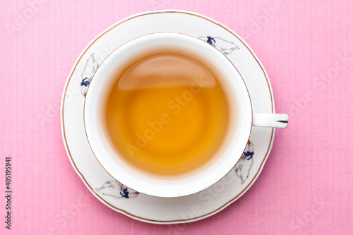 A cup of tea on pastel pink colors. View from above