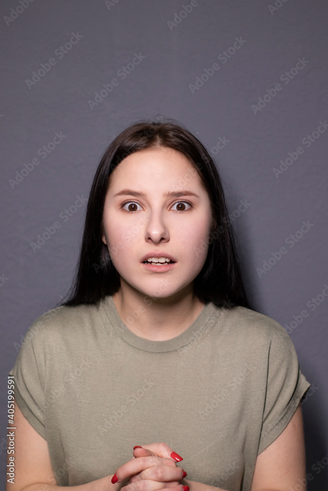 portrait of charming scared brunette woman in marsh color t-shirt on grey wall background. actress acting, emotion portrait of charming scared brunette woman in marsh color t-shirt on grey wall background. actress acting, emotion