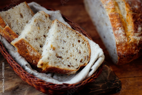 Pieces of sliced bread lie in a wicker basket on a wooden table. Fresh homemade baking of yeast-free bread with your own hands. Top view