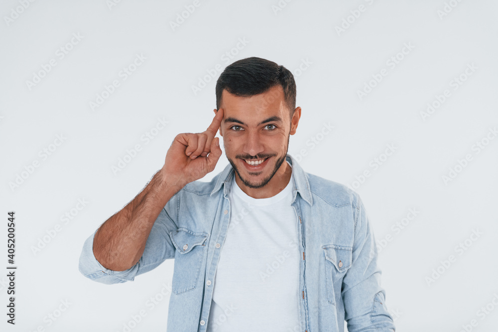 Young handsome man standing indoors against white background Young handsome man standing indoors against white background