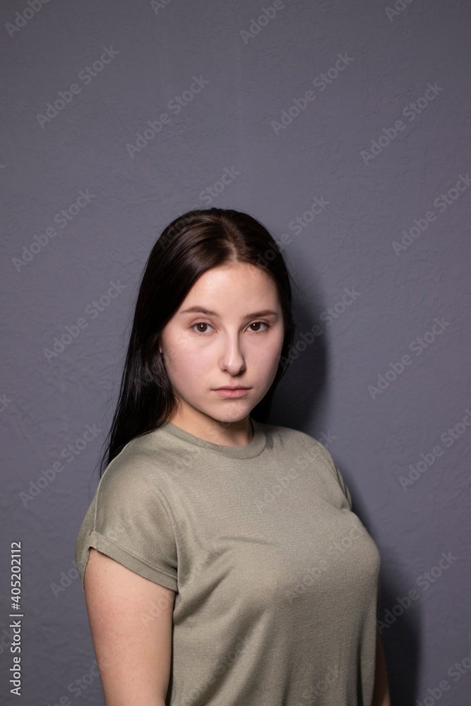 emotional portrait of charming brunette woman in marsh color t-shirt on grey wall background. actress acting, emotion emotional portrait of charming brunette woman in marsh color t-shirt on grey wall background. actress acting, emotion