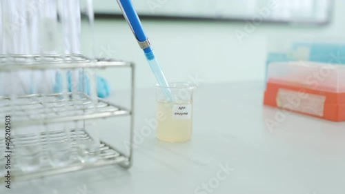 Scientist teaching chemistry experiment online in laboratory. Wearing lab coat and glove. Education and technology, social distance concept. Transfer pH buffer into test tube by using micropipette photo