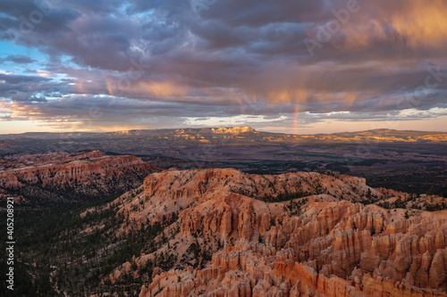 Views of sandstone Hoodoos, storm clouds and a rainbow at sunset/sunrise from Inspiration Point in Bryce Canyon National Park, Utah, USA. 