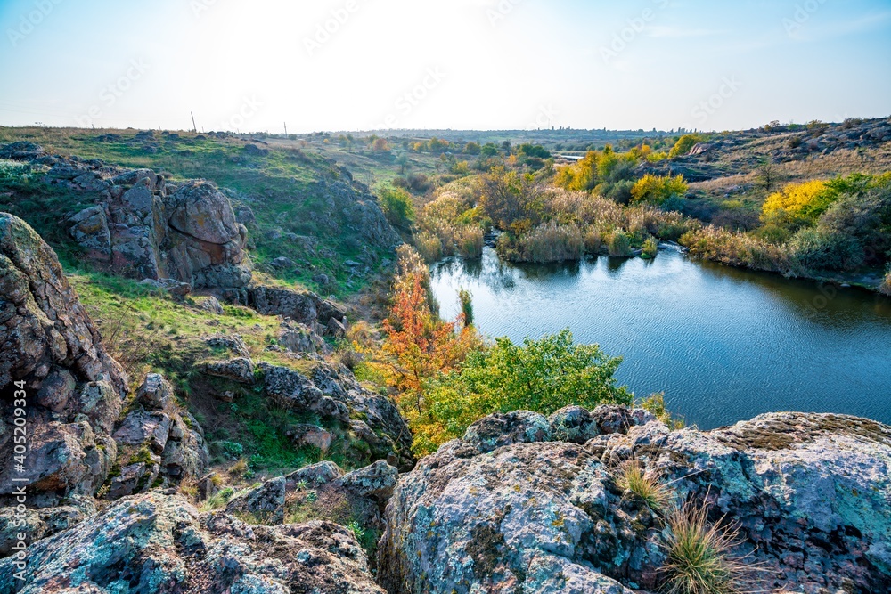 Beautiful small river among large stones and green vegetation on the hills in Ukraine
