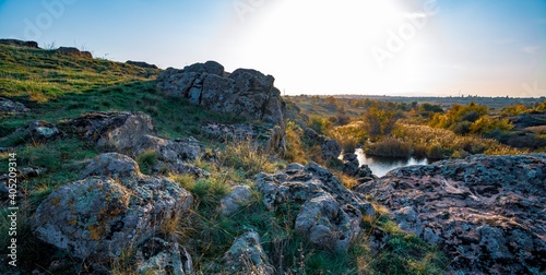 Beautiful small river among large stones and green vegetation on the hills in Ukraine