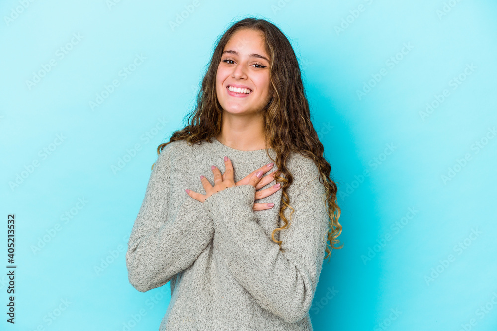 Young caucasian curly hair woman isolated has friendly expression, pressing palm to chest. Love concept. Young caucasian curly hair woman isolated has friendly expression, pressing palm to chest. Love concept.