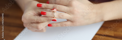 Woman s hand removes wedding ring from her finger. Family relationship and divorce concept