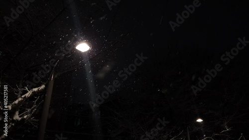 Bright street lights in the dark evening snow