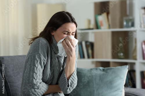 Woman suffering flu symptoms blowing on cloth