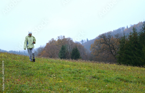 Tourist walk in the autumn on a green field as an active movement