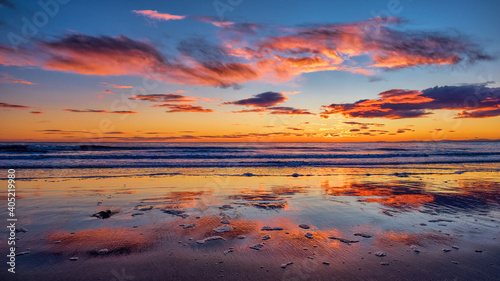 Sunrise over the North Sea off Brora beach in the Highlands with dawn colors reflected in wet sand © HighlandBrochs.com