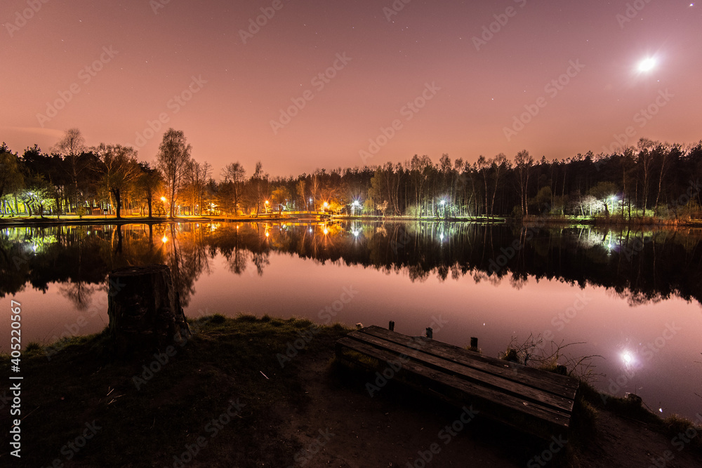 Night park, evening sky with stars. Park in city lake with refleNight park, evening sky with stars. Park in city lake with reflections on water. Sosnowiec, Polandctions in water. Sosnowiec, Poland
