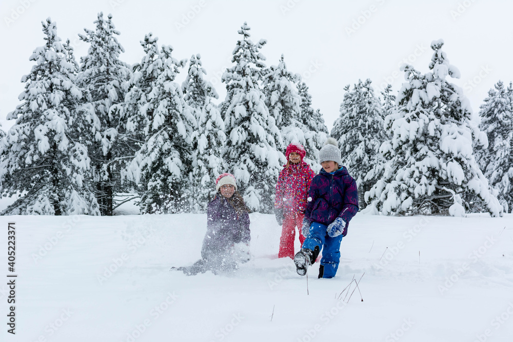 Group of three kids girls playing in snow together. Group of children playing on snow in winter time