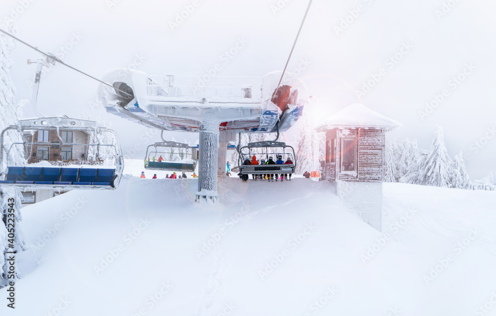 Skiers get off the ski lift.Image taken from behind.