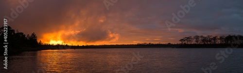 Panoramic beautiful view of sunrise over the lake.