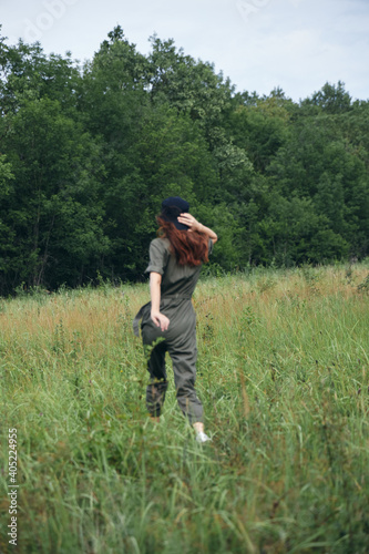 Woman Green jumpsuit walk tall grass field back view © SHOTPRIME STUDIO
