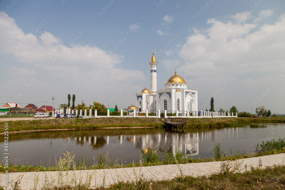 white mosque on the shore of the lake