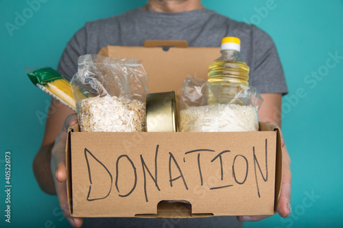 A man holding a donation box of different products © burdun