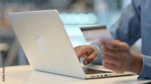 Online Shopping Payment on Laptop by African Man, Close Up 