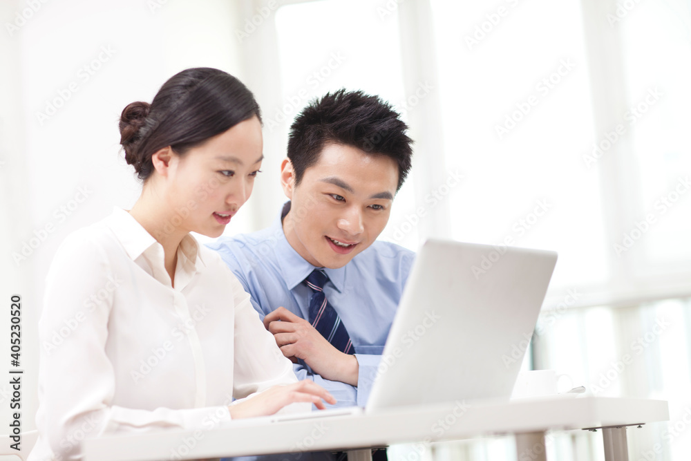 Businessman and businesswoman discussing working on computer Businessman and businesswoman discussing working on computer