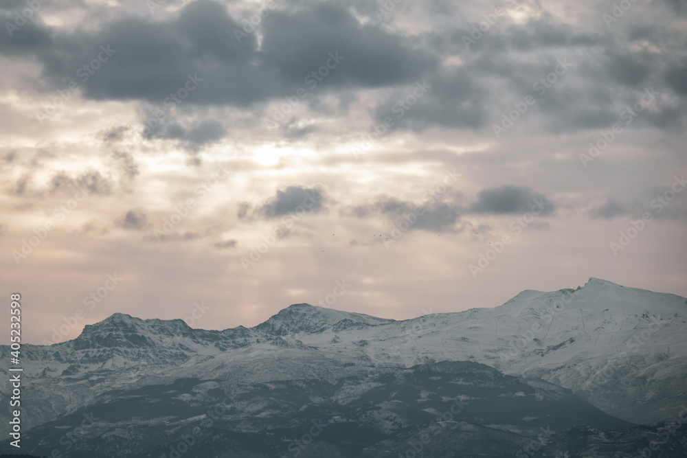 View of the highest peaks of Sierra Nevada (Granada, Spain) on a cloudy winter morning at sunrise