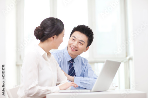 Businessman and businesswoman discussing working on computer