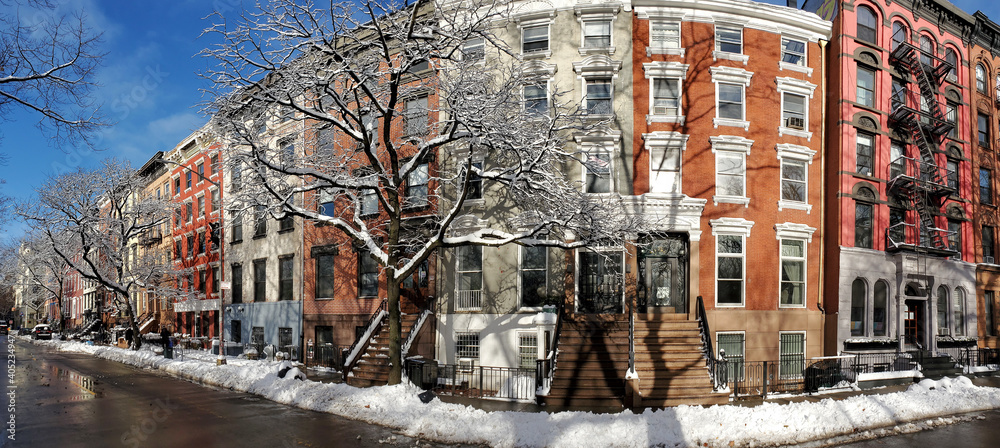 Φωτογραφία Sun shines on a snow covered block of colorful buildings along 10th Street in th