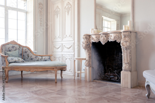 Luxurious light interior of the living room in the baroque style as in a royal castle with old stylish vintage furniture, columns, stucco on the walls
