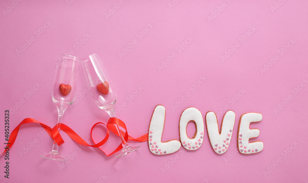 A glasses with hearts inside them, wrapped with a red ribbon in the shape of a heart. Gingerbread the inscription Love.