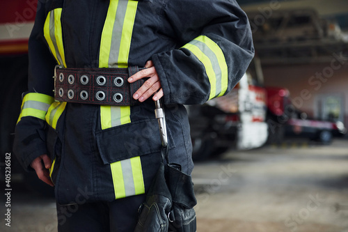 Close up view. Female firefighter in protective uniform standing near truck