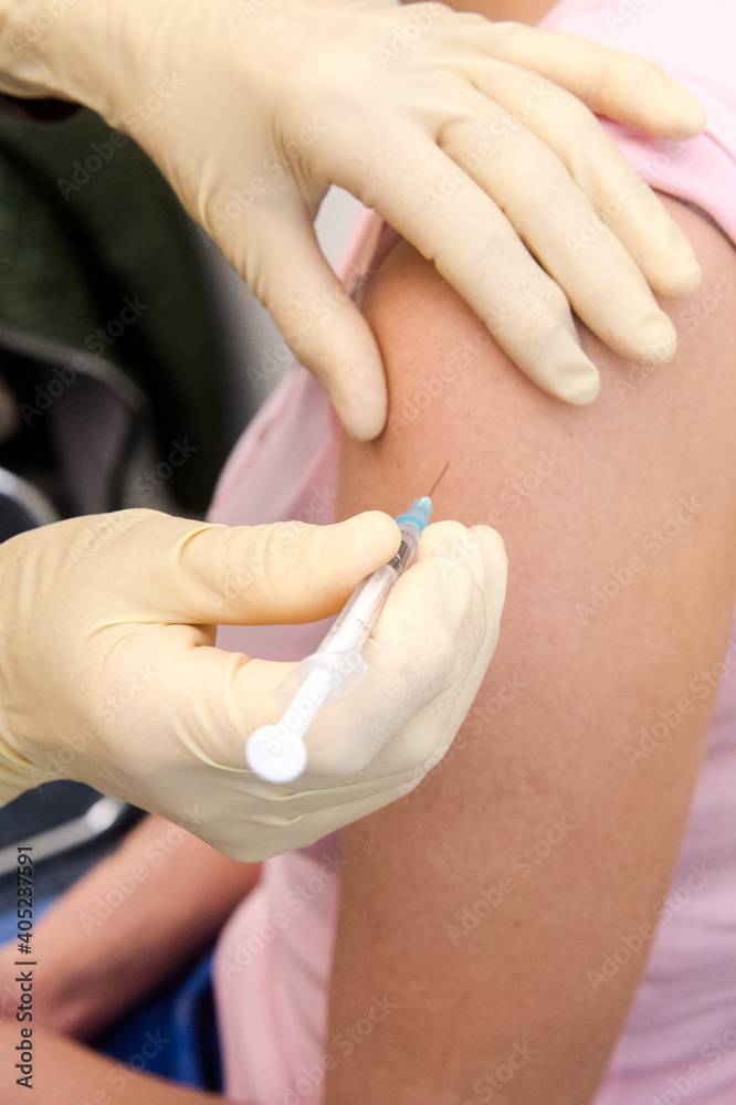 Eine Patientin erhält eine Impfdosis in die Schulter - Coronaimpfung