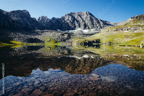 Mountains are reflected in the clear transparent water of a mountain lake