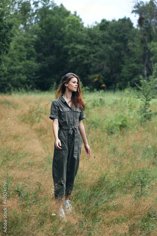 Woman in the forest in the meadow gray jumpsuit 