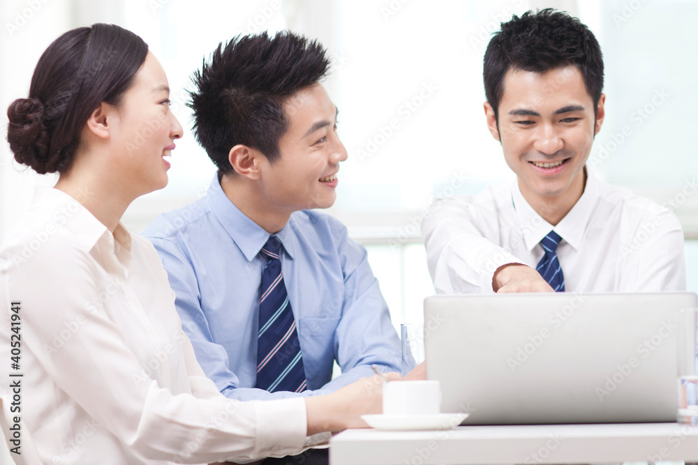 Group of businesspeople discussing working on computer Group of businesspeople discussing working on computer