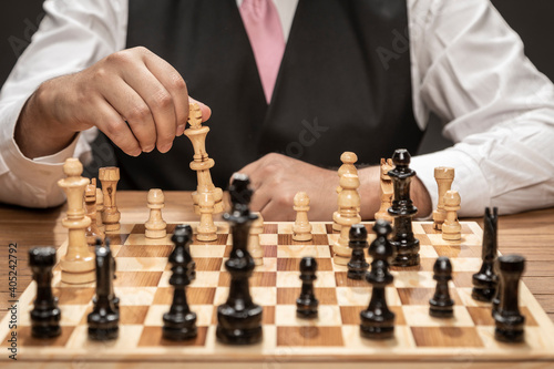Man playing on fine wooden chess board.