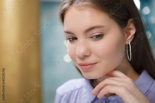 Close up of a charming woman wearing diamond hoop earrings