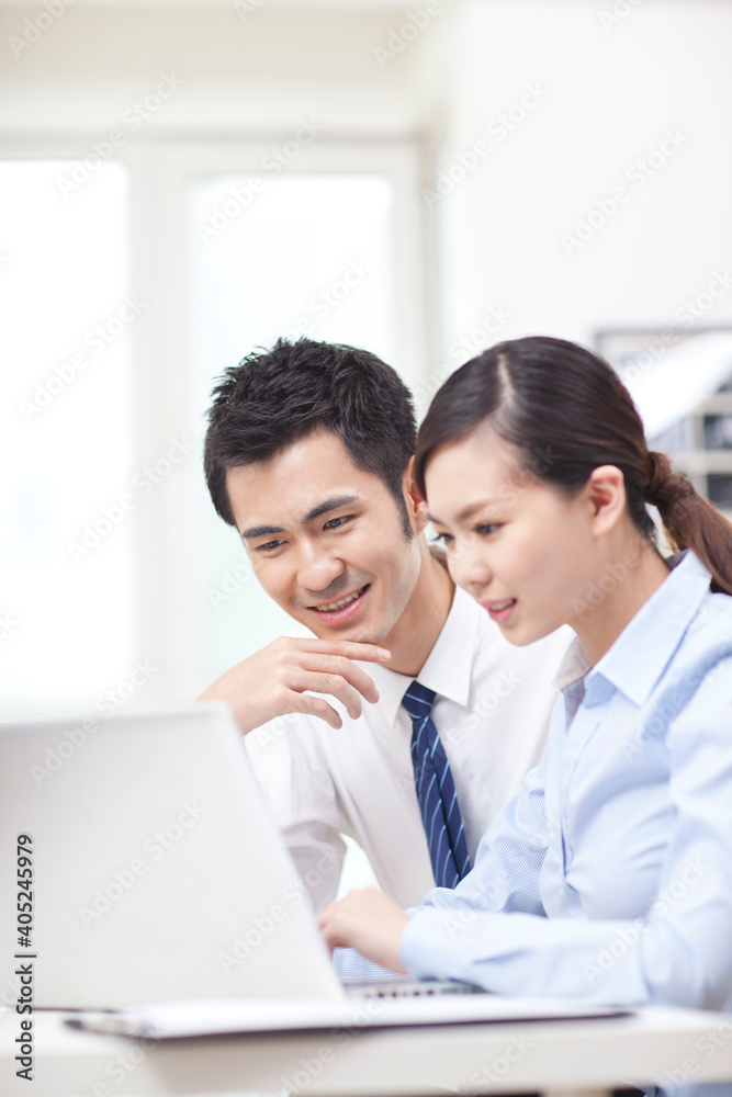 Businessman and businesswoman discussing working on computer Businessman and businesswoman discussing working on computer