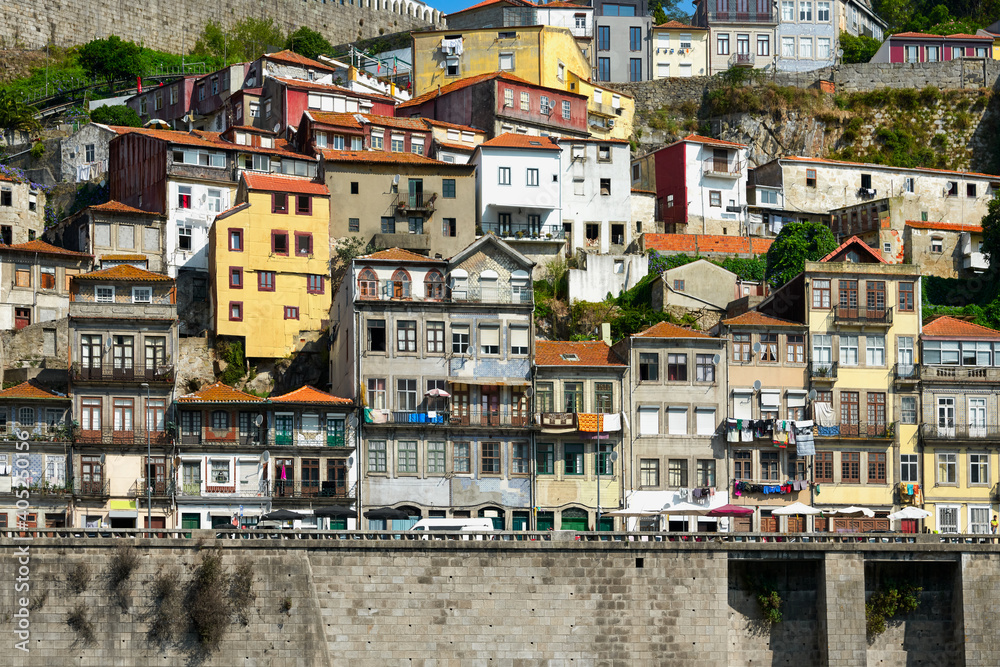 Colorful facades of old houses with clothes hanging on a rope on the banks of the Douro River in Porto.