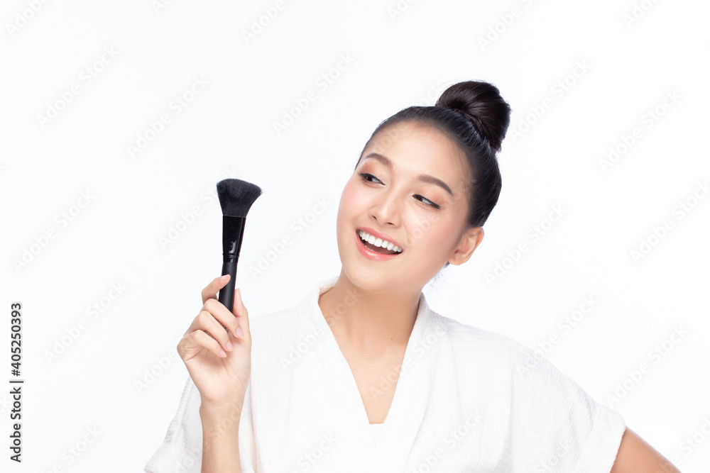 Closeup portrait of beautiful happy young girl holding brush near face isolated on white background. Beauty and cosmetics concept. Closeup portrait of beautiful happy young girl holding brush near face isolated on white background. Beauty and cosmetics concept.