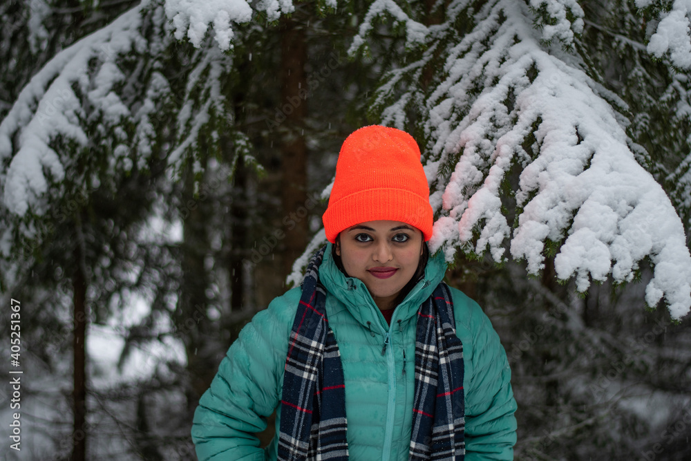 A beautiful caucasian young woman in a winter wonderland enjoying the snow fashion photoshoot wearing colourful jacket and red cap A beautiful caucasian young woman in a winter wonderland enjoying the snow fashion photoshoot wearing colourful jacket and red cap