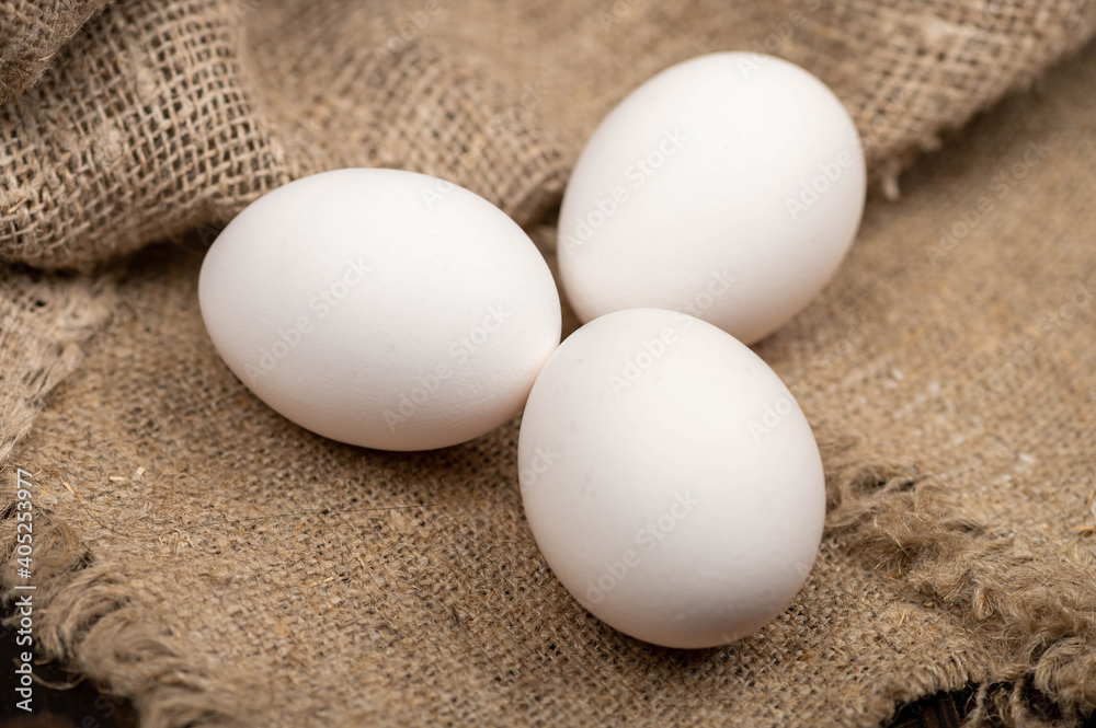Chicken eggs on a background of homespun fabric with a rough texture. Close-up, selective focus. Chicken eggs on a background of homespun fabric with a rough texture. Close-up, selective focus.