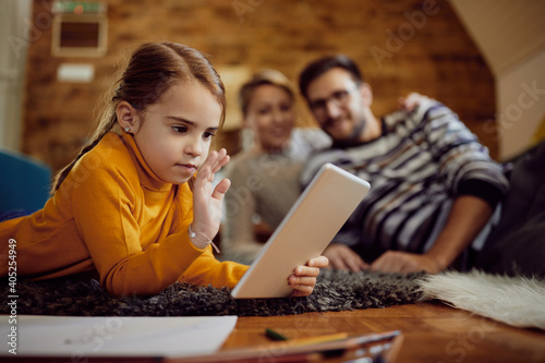 Little girl waving during video call over digital tablet at home. © Drazen