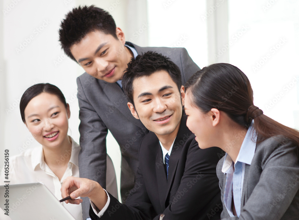 Group of businesspeople discussing working on computer Group of businesspeople discussing working on computer